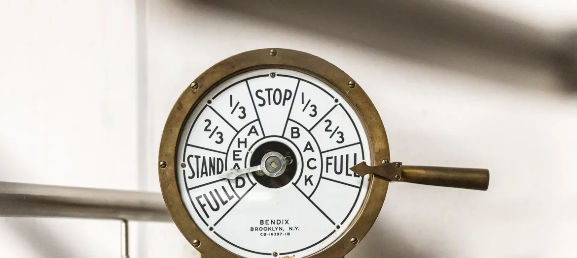 Historischer Maschinentelegraf auf einem Schiff, runde Messinganzeige mit Skala ‚Stop/Stand/Full‘ (Ahead/Back); Hebel steht auf ‚Full‘.